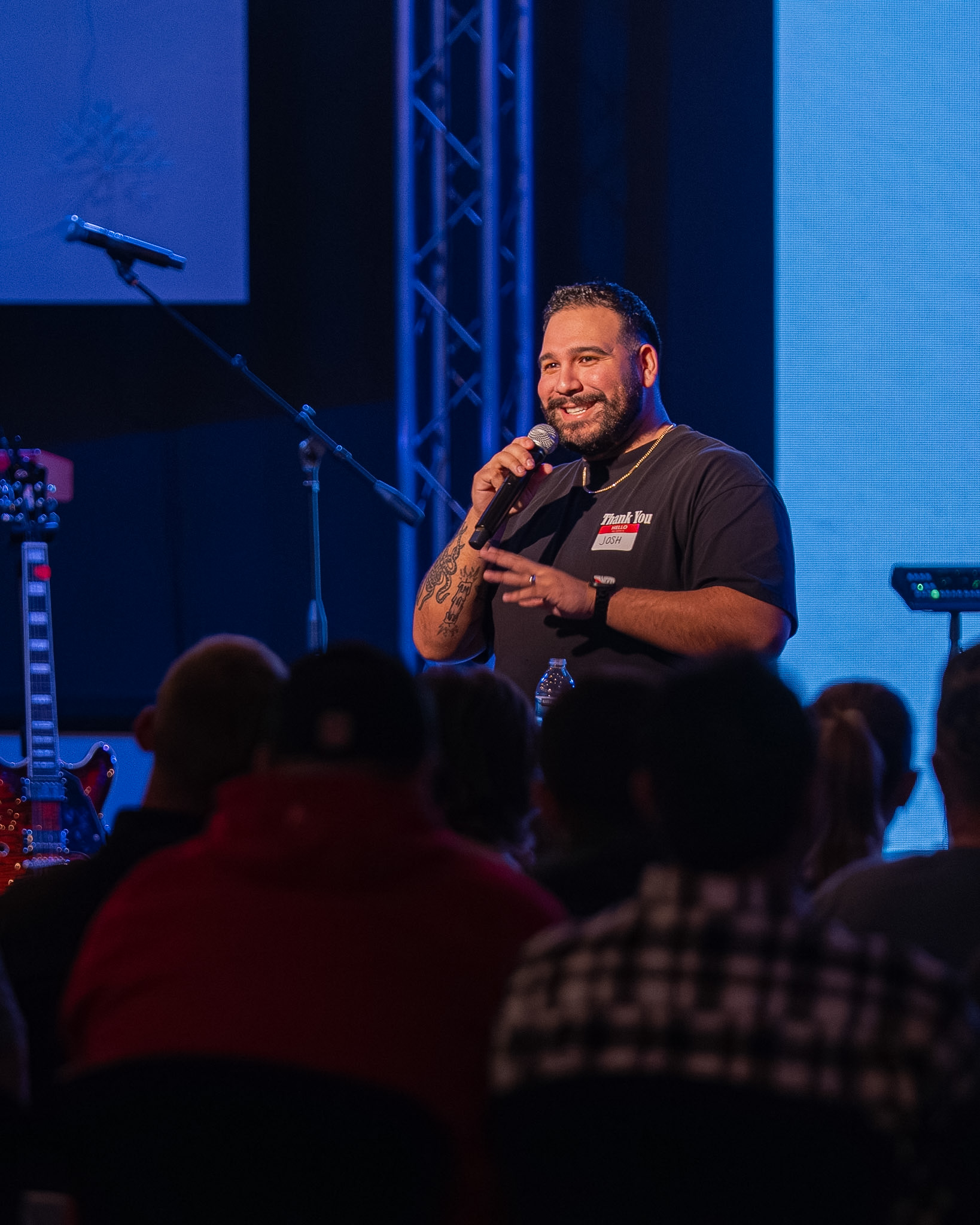 A speaker addressing the crowd on stage during a Young Adults gathering