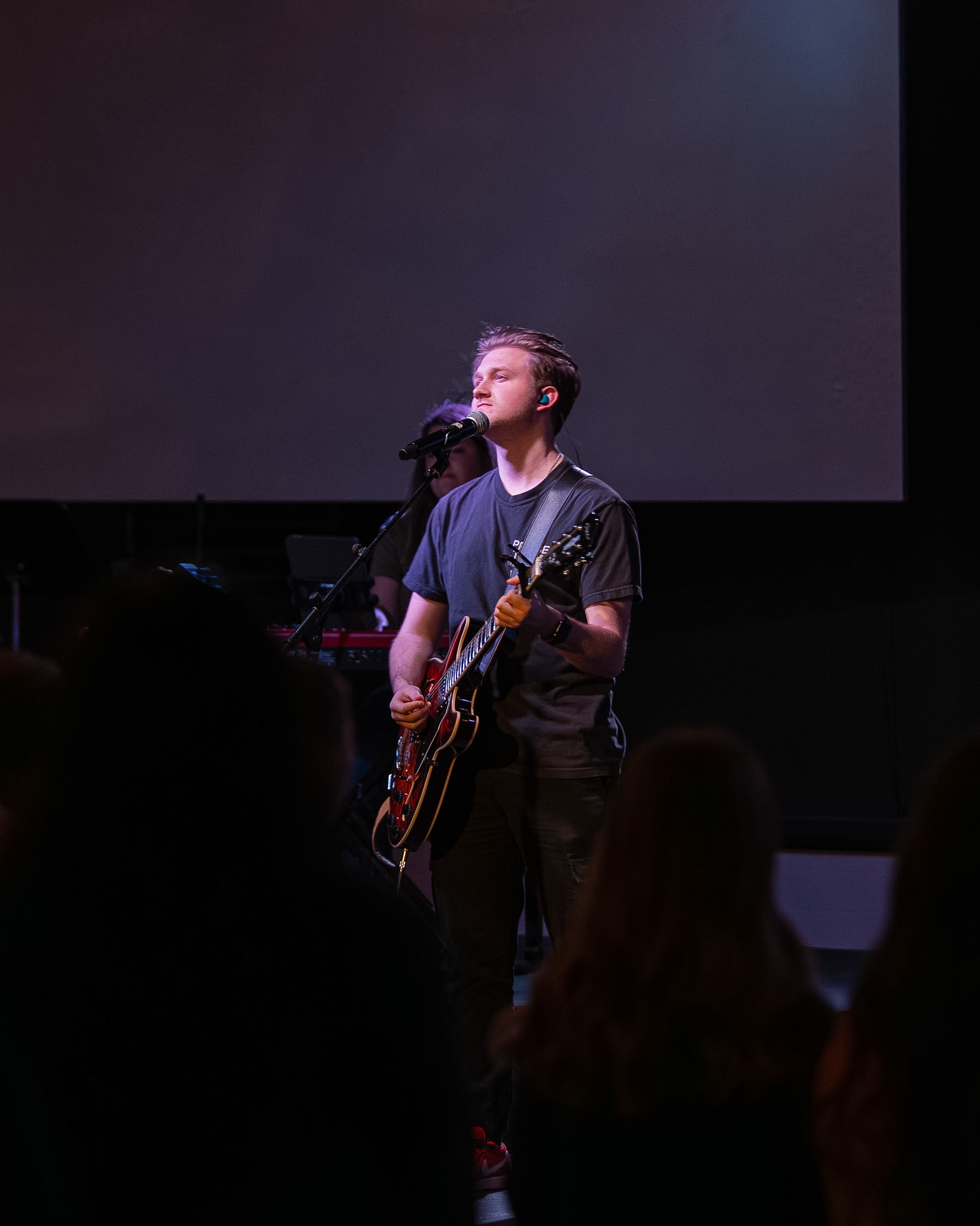 A guitarist performing on stage during a Young Adults worship night