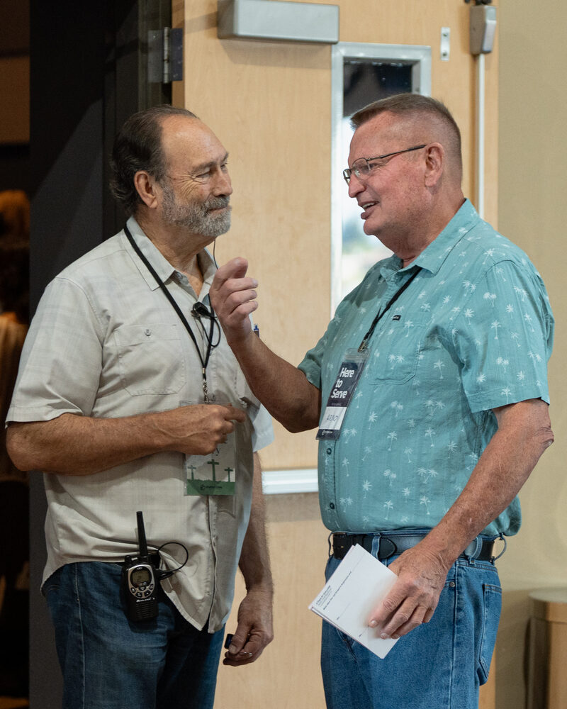 Two men talking together at a Cove Seniors event