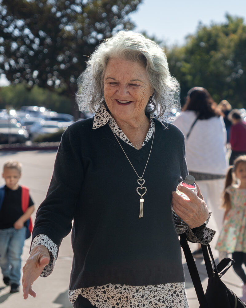 A woman smiling while walking outdoors at a Cove Seniors event