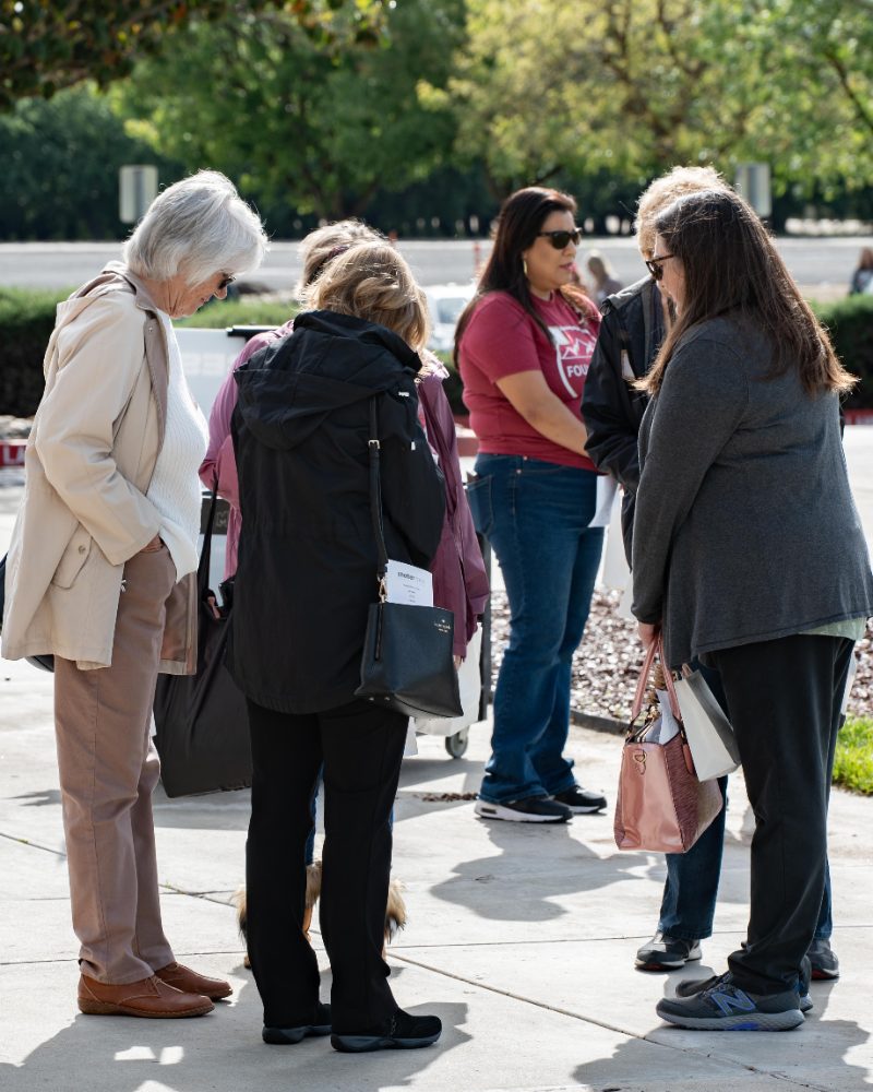 A group of women standing and talking together outdoors at a Cove Women event