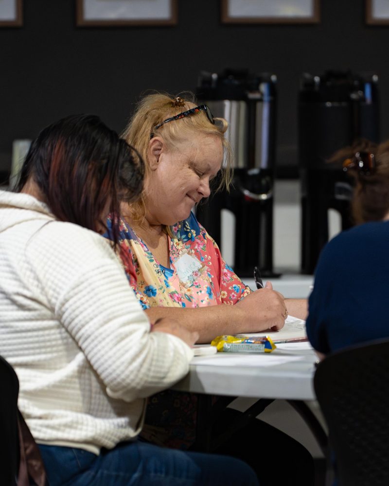 Two women writing and journaling together during a Cove Women gathering