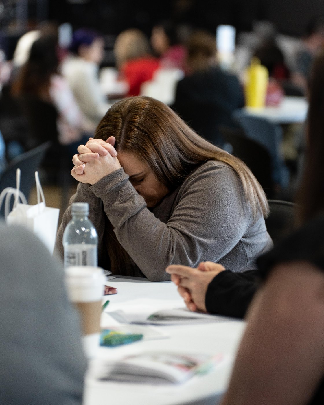 A woman with her head bowed in prayer during a Cove Women gathering