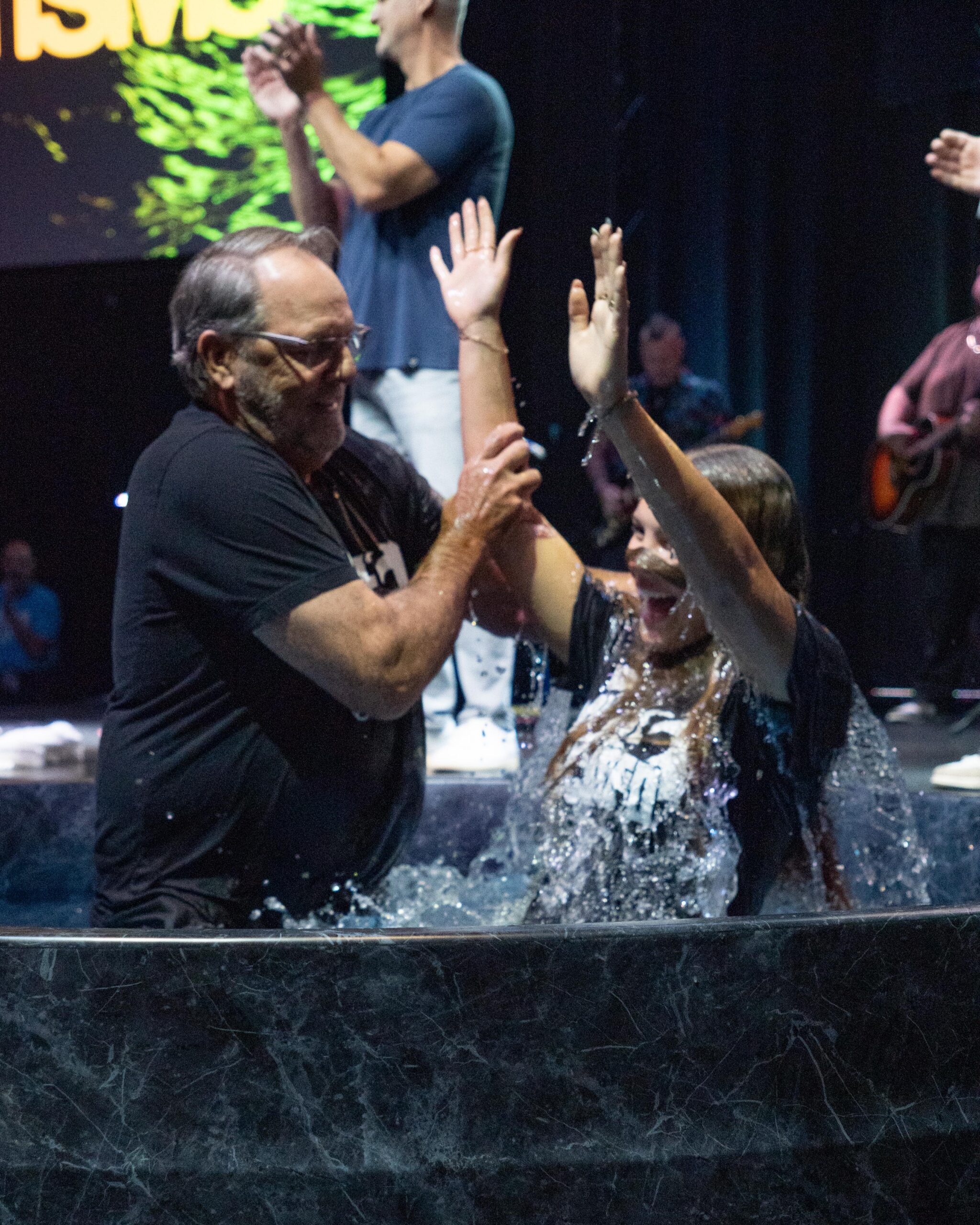 A pastor high fiving a woman moments after she gets baptized at Shelter Cove, celebrating together