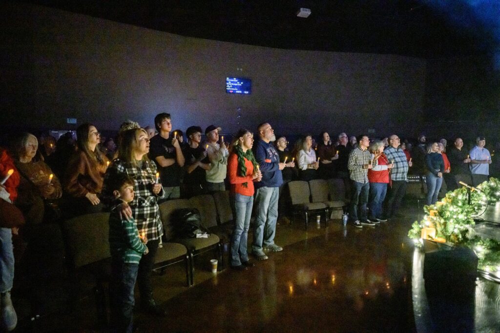The congregation standing together with candles at a Christmas service
